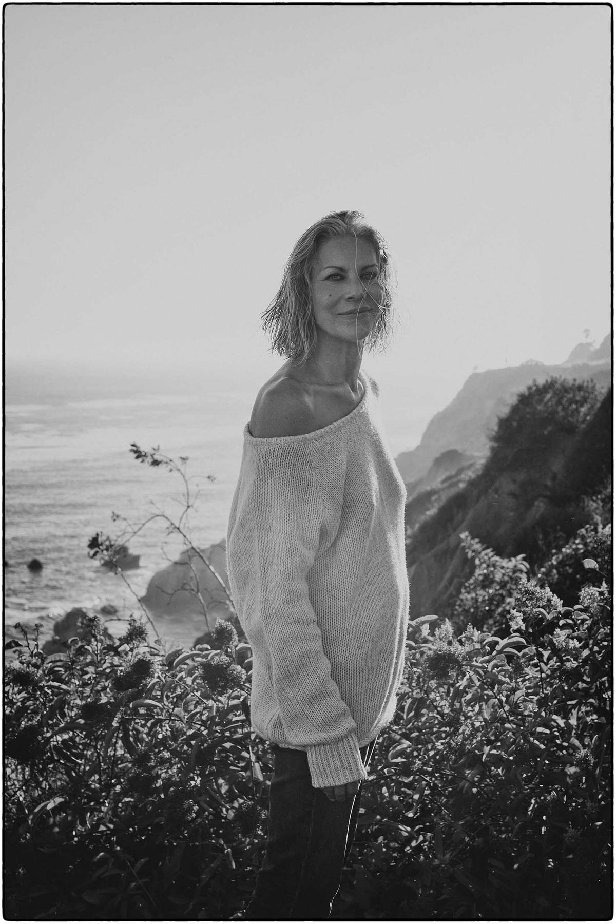 Mature woman on a cliff smiling at the camera