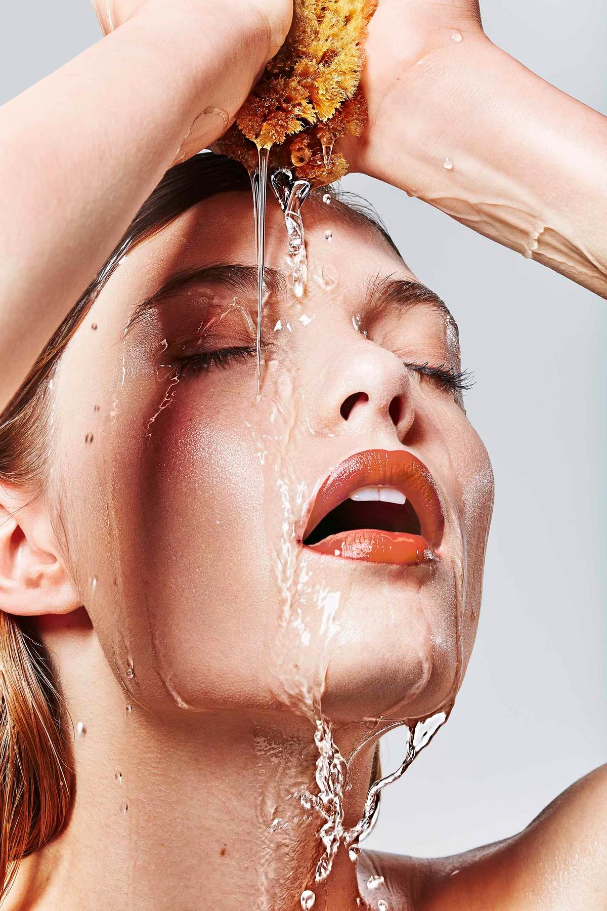 young woman squeezing a sponge above her face while water is running down her faceU9A1043_v2 copy.jpg