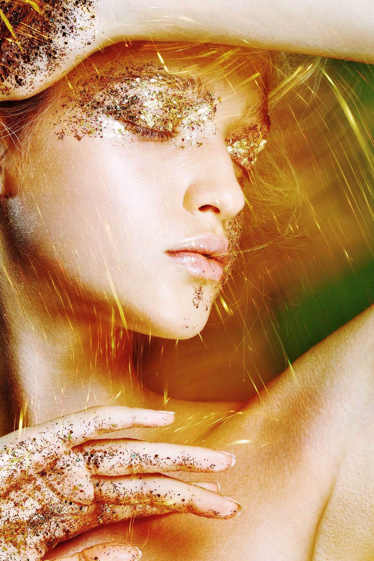 SIDE VIEW OF A FEMALE FACE WITH GOLDEN GLITTER ON HER EYES AND LIGHTING SPARKS