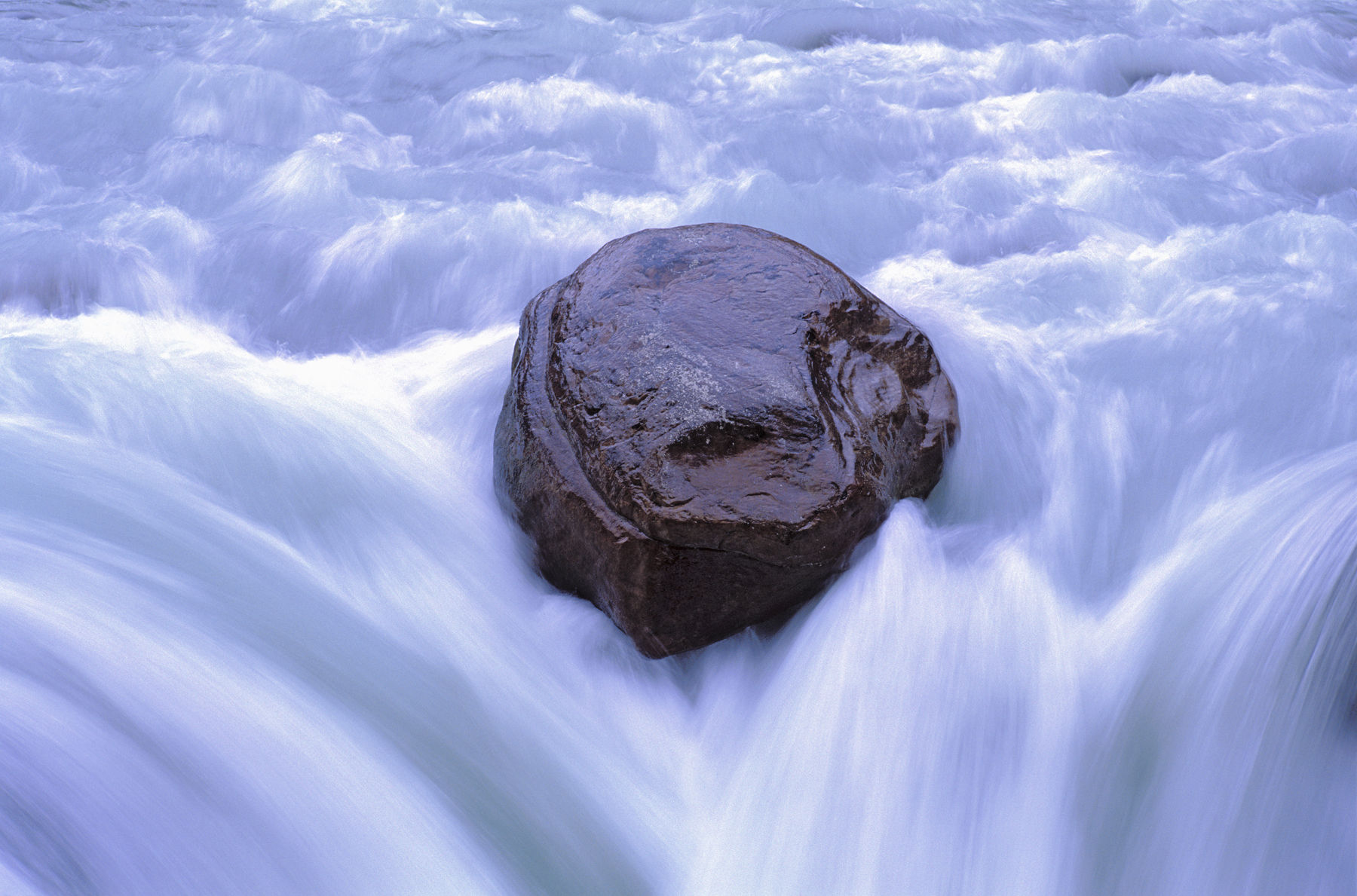 Single Rock in River Stream. Long exposure. Getty Images #10189071 Single Rock in River Stream.