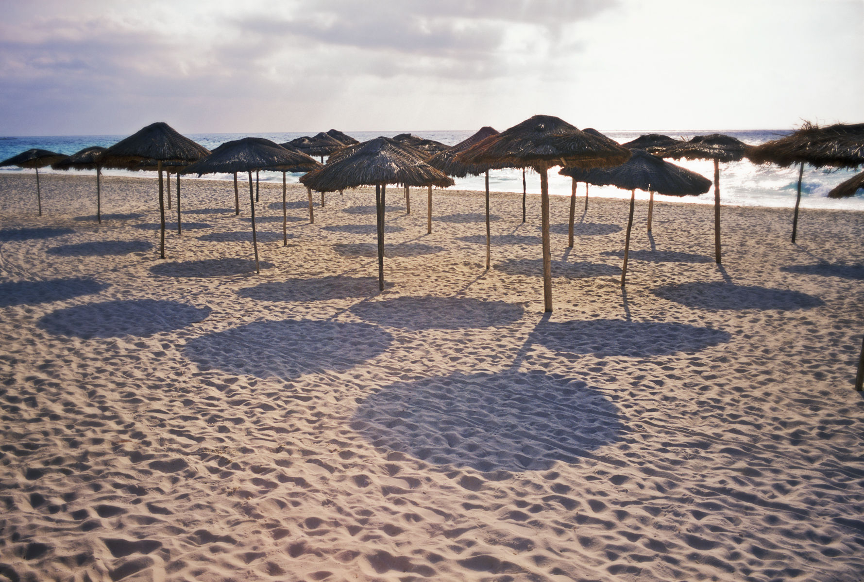 Mexico, Playa del Carmen. Palapas casting shadows on the beach. Getty Images 200069795-001 Mexico, Quintana Roo, Playa del Carmen, palapas and shadows on b