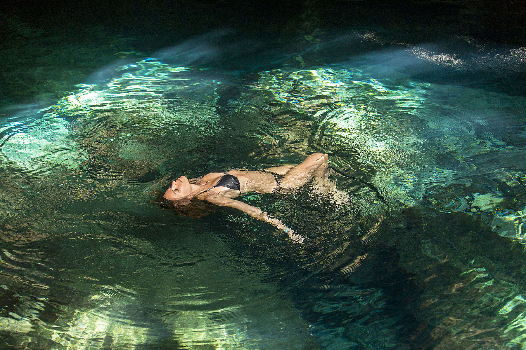 Woman floating in water in a relaxed pose in a pool situated in a cenote.Getty Images #150086968 Young woman swimming in a cenote