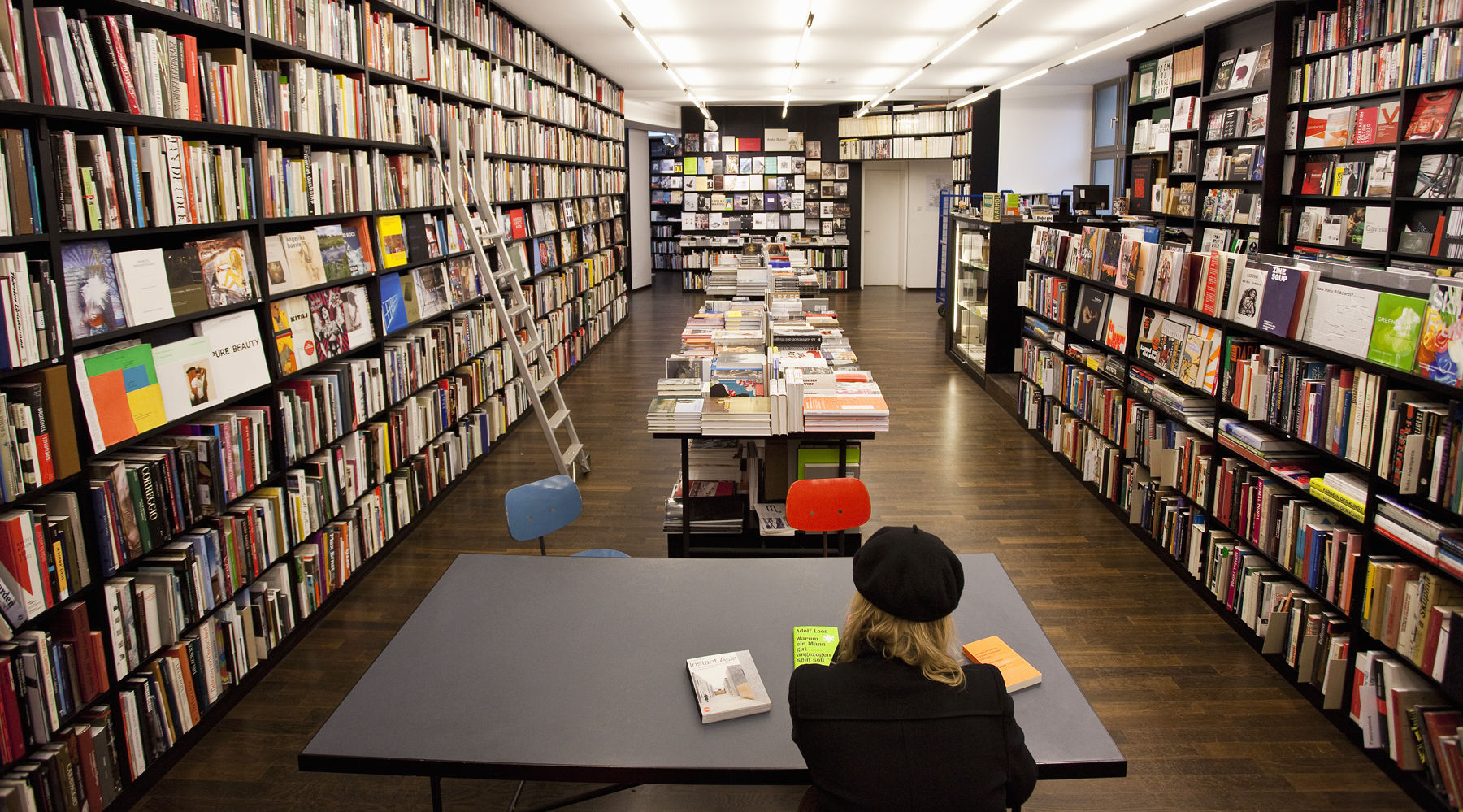 woman seated at a table in a book store woman seated at a table in a book store