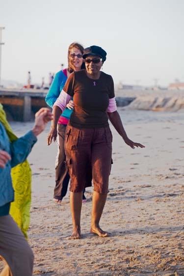 African American female senior dances and exercises in senior exercise class on Playa Del Rey Beach in Los Angeles, California Black senior woman dances and exercises at beach