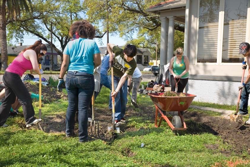 College teens work on water system in yard of home outdoors in New Orleans, Louisiana to rebuild the city Teens volunteer rebuilding New Orleans outdoors