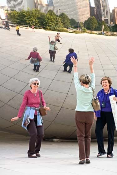Three mature females act silly and have fun at mirrored sculpture in Millineum Park, Chicago Illinois Three senior women act silly in front of Millineum Park mirror sculpture