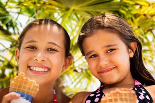 Two cute girls eating ice cream while taking a break from swimming while on holiday. LifeStyle Image - Girls Enjoying Ice Cream.jpg