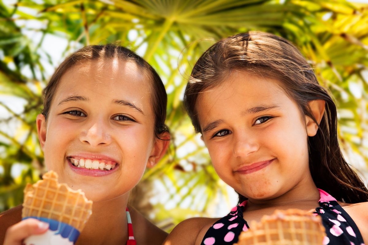 Two cute girls eating ice cream while taking a break from swimming while on holiday. LifeStyle Image - Girls Enjoying Ice Cream.jpg
