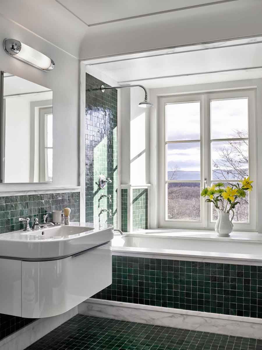 This new stone home recalls centuries -old Huguenot houses built along the Hudson River long ago, while it incorporates the latest technology and materials of the 21st century.  Fieldstone rock facing conceals insulation made from recycled blue jeans and ductwork for geothermal heating and cooling.  The 26" thick exterior walls create commodious windowsills and give a primordial sense of security.  Drawing inspiration from early American center hall plans with rooms flanking a stair on each side, this modern home departs from its Colonial cousin when it comes to light and height.  The living room ceiling soars to 14 feet, and is lit by an enormous Italian Stillnovo chandelier. The kitchen features a fireplace of epic proportions, but every modern convenience is concealed behind elegant stainless steel cabinetry.    Hudson Valley House 11.jpg