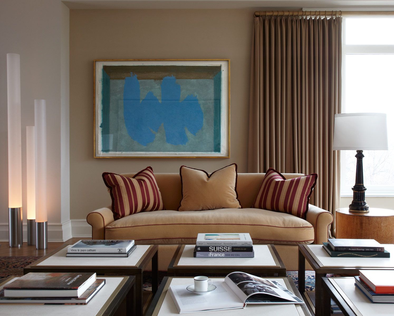Belsey & Mahla Architects provided architectural and interior design services for this apartment renovation in New York City's newest landmark.The grand living room with dramatic park views has wide stripes on the walls, rich wool draperies on reeded brass rods, and six matching custom bronze coffee tables. A map of Haussmann's Plan for Paris, once in the Louvre's collection, occupies one wall. French aspen paneling and a ribbed oval plaster dome outfit the library; the paneling conceals a secret passage to the master suite.The dining room features French factory lights aimed to illuminate the embroidered silk draperies, and a 1940's French commode with intricate marquetry. The entry vestibule floor is made of French limestone and Saint Laurent marble. A wall-mounted console rests on found metal springs rescued from an antique shop.Paired French doors with beveled glass panes and cremone bolts connect the apartment rooms. The client's collection of modern art masterworks on paper 15 Central Park West