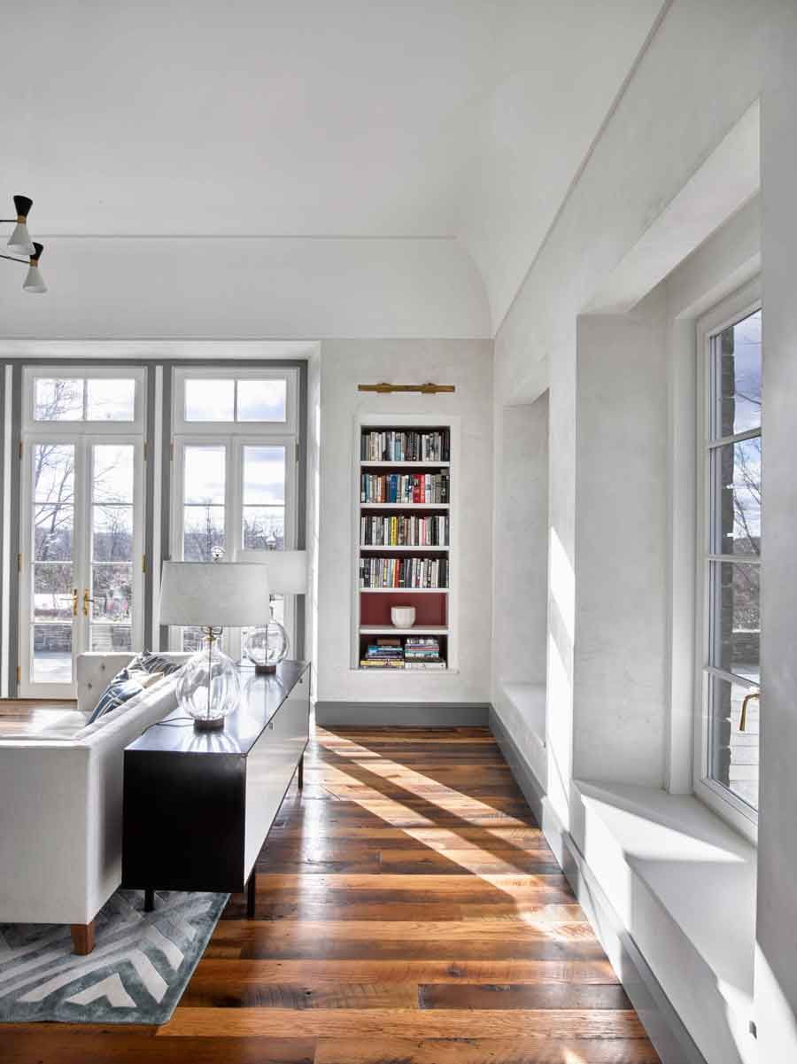 This new stone home recalls centuries -old Huguenot houses built along the Hudson River long ago, while it incorporates the latest technology and materials of the 21st century.  Fieldstone rock facing conceals insulation made from recycled blue jeans and ductwork for geothermal heating and cooling.  The 26" thick exterior walls create commodious windowsills and give a primordial sense of security.  Drawing inspiration from early American center hall plans with rooms flanking a stair on each side, this modern home departs from its Colonial cousin when it comes to light and height.  The living room ceiling soars to 14 feet, and is lit by an enormous Italian Stillnovo chandelier. The kitchen features a fireplace of epic proportions, but every modern convenience is concealed behind elegant stainless steel cabinetry.    Hudson Valley House 3.jpg