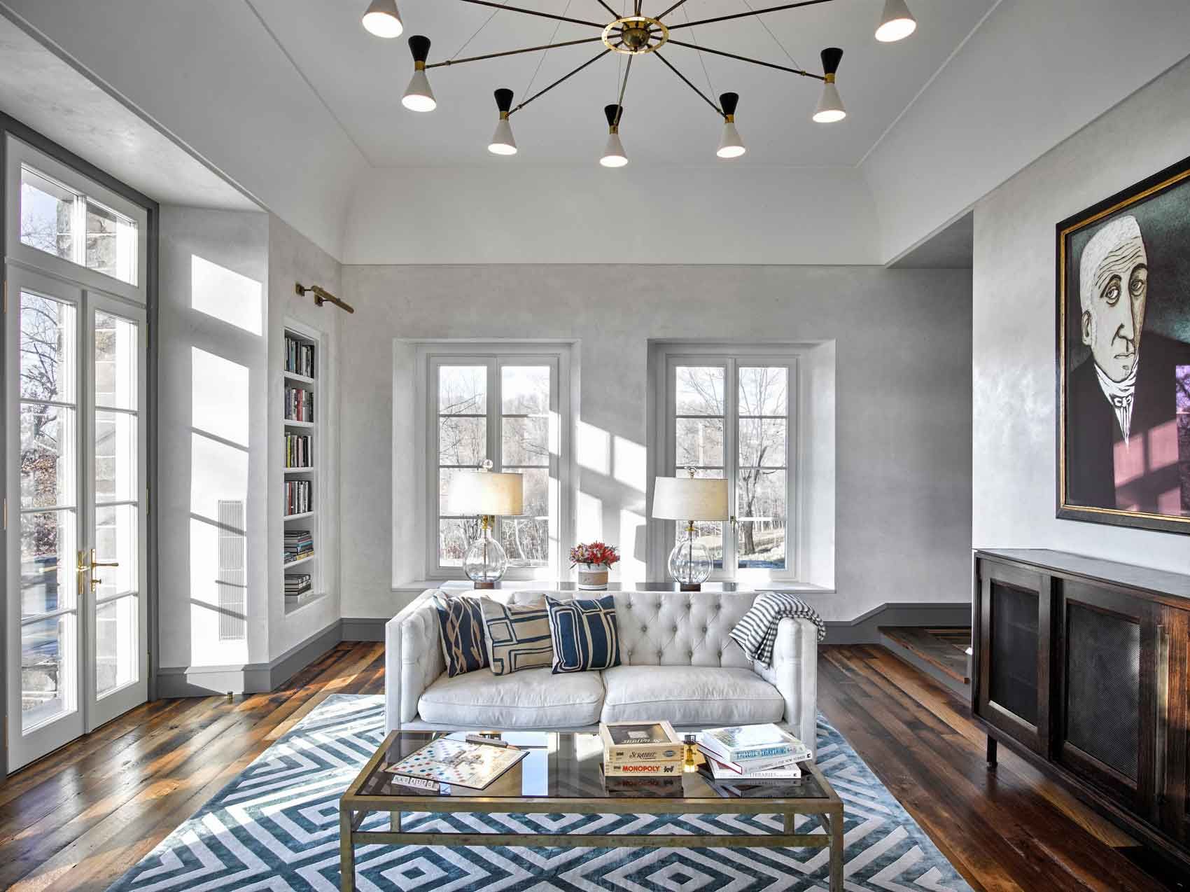 This new stone home recalls centuries -old Huguenot houses built along the Hudson River long ago, while it incorporates the latest technology and materials of the 21st century.  Fieldstone rock facing conceals insulation made from recycled blue jeans and ductwork for geothermal heating and cooling.  The 26" thick exterior walls create commodious windowsills and give a primordial sense of security.  Drawing inspiration from early American center hall plans with rooms flanking a stair on each side, this modern home departs from its Colonial cousin when it comes to light and height.  The living room ceiling soars to 14 feet, and is lit by an enormous Italian Stillnovo chandelier. The kitchen features a fireplace of epic proportions, but every modern convenience is concealed behind elegant stainless steel cabinetry.    Hudson Valley House 12.jpg