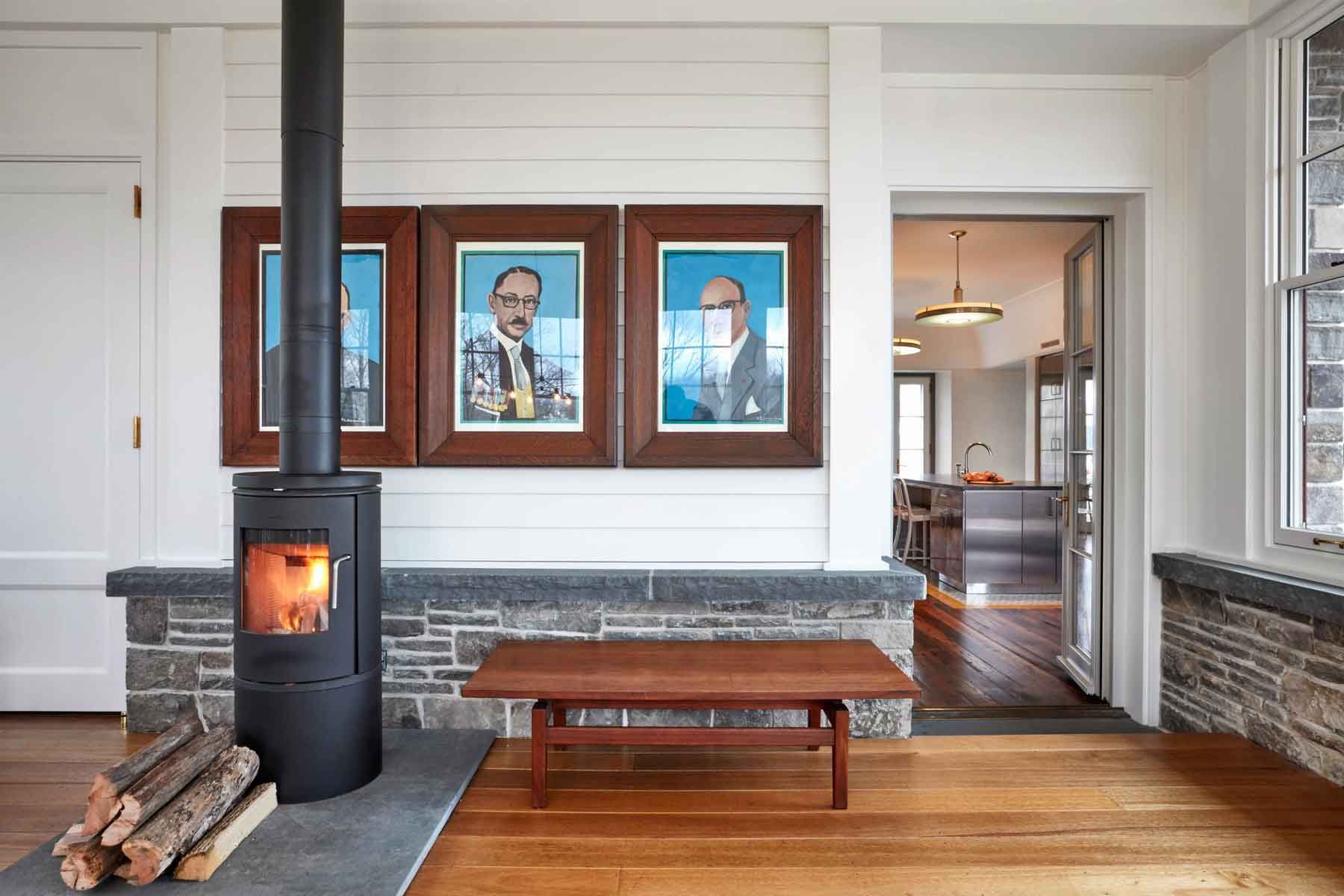 This new stone home recalls centuries -old Huguenot houses built along the Hudson River long ago, while it incorporates the latest technology and materials of the 21st century.  Fieldstone rock facing conceals insulation made from recycled blue jeans and ductwork for geothermal heating and cooling.  The 26" thick exterior walls create commodious windowsills and give a primordial sense of security.  Drawing inspiration from early American center hall plans with rooms flanking a stair on each side, this modern home departs from its Colonial cousin when it comes to light and height.  The living room ceiling soars to 14 feet, and is lit by an enormous Italian Stillnovo chandelier. The kitchen features a fireplace of epic proportions, but every modern convenience is concealed behind elegant stainless steel cabinetry.    Hudson Valley House 5.jpg