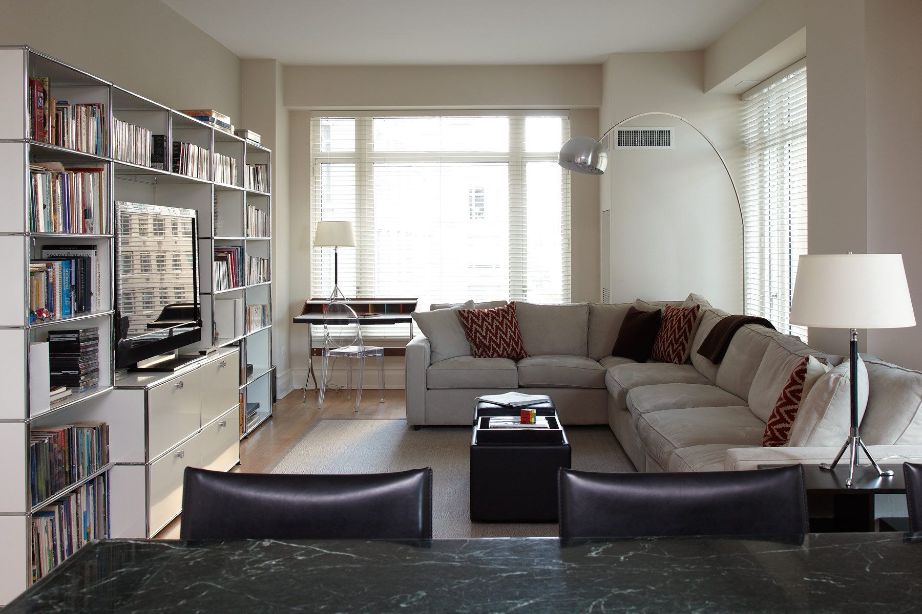 Belsey & Mahla Architects provided architectural and interior design services for this apartment renovation in New York City's newest landmark.The grand living room with dramatic park views has wide stripes on the walls, rich wool draperies on reeded brass rods, and six matching custom bronze coffee tables. A map of Haussmann's Plan for Paris, once in the Louvre's collection, occupies one wall. French aspen paneling and a ribbed oval plaster dome outfit the library; the paneling conceals a secret passage to the master suite.The dining room features French factory lights aimed to illuminate the embroidered silk draperies, and a 1940's French commode with intricate marquetry. The entry vestibule floor is made of French limestone and Saint Laurent marble. A wall-mounted console rests on found metal springs rescued from an antique shop.Paired French doors with beveled glass panes and cremone bolts connect the apartment rooms. The client's collection of modern art masterworks on paper 15 Central Park West