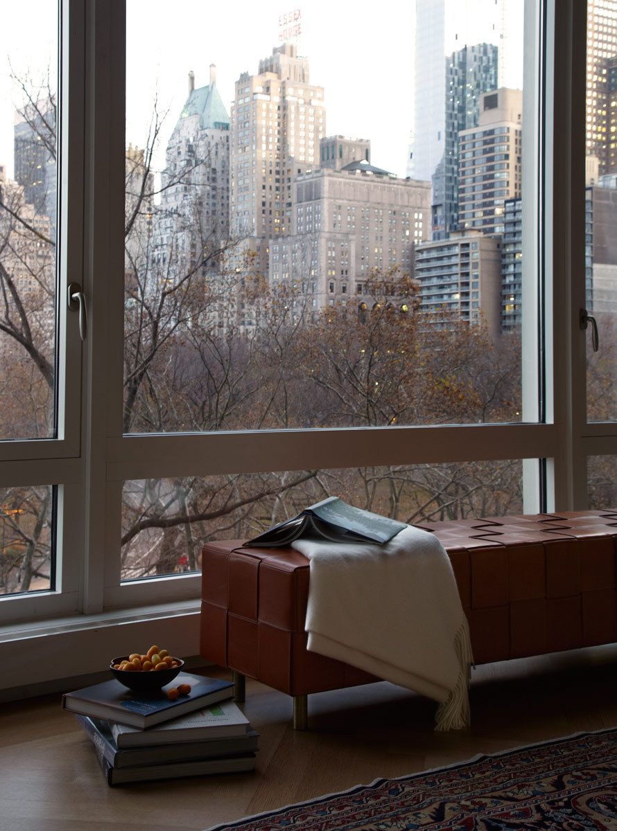 Belsey & Mahla Architects provided architectural and interior design services for this apartment renovation in New York City's newest landmark.The grand living room with dramatic park views has wide stripes on the walls, rich wool draperies on reeded brass rods, and six matching custom bronze coffee tables. A map of Haussmann's Plan for Paris, once in the Louvre's collection, occupies one wall. French aspen paneling and a ribbed oval plaster dome outfit the library; the paneling conceals a secret passage to the master suite.The dining room features French factory lights aimed to illuminate the embroidered silk draperies, and a 1940's French commode with intricate marquetry. The entry vestibule floor is made of French limestone and Saint Laurent marble. A wall-mounted console rests on found metal springs rescued from an antique shop.Paired French doors with beveled glass panes and cremone bolts connect the apartment rooms. The client's collection of modern art masterworks on paper 15 Central Park West