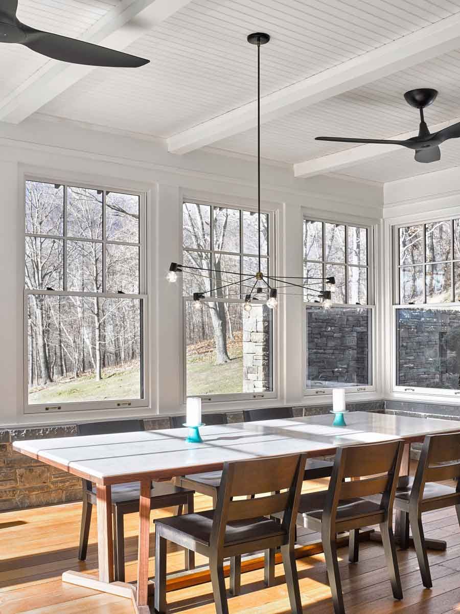 This new stone home recalls centuries -old Huguenot houses built along the Hudson River long ago, while it incorporates the latest technology and materials of the 21st century.  Fieldstone rock facing conceals insulation made from recycled blue jeans and ductwork for geothermal heating and cooling.  The 26" thick exterior walls create commodious windowsills and give a primordial sense of security.  Drawing inspiration from early American center hall plans with rooms flanking a stair on each side, this modern home departs from its Colonial cousin when it comes to light and height.  The living room ceiling soars to 14 feet, and is lit by an enormous Italian Stillnovo chandelier. The kitchen features a fireplace of epic proportions, but every modern convenience is concealed behind elegant stainless steel cabinetry.    Hudson Valley House 4.jpg