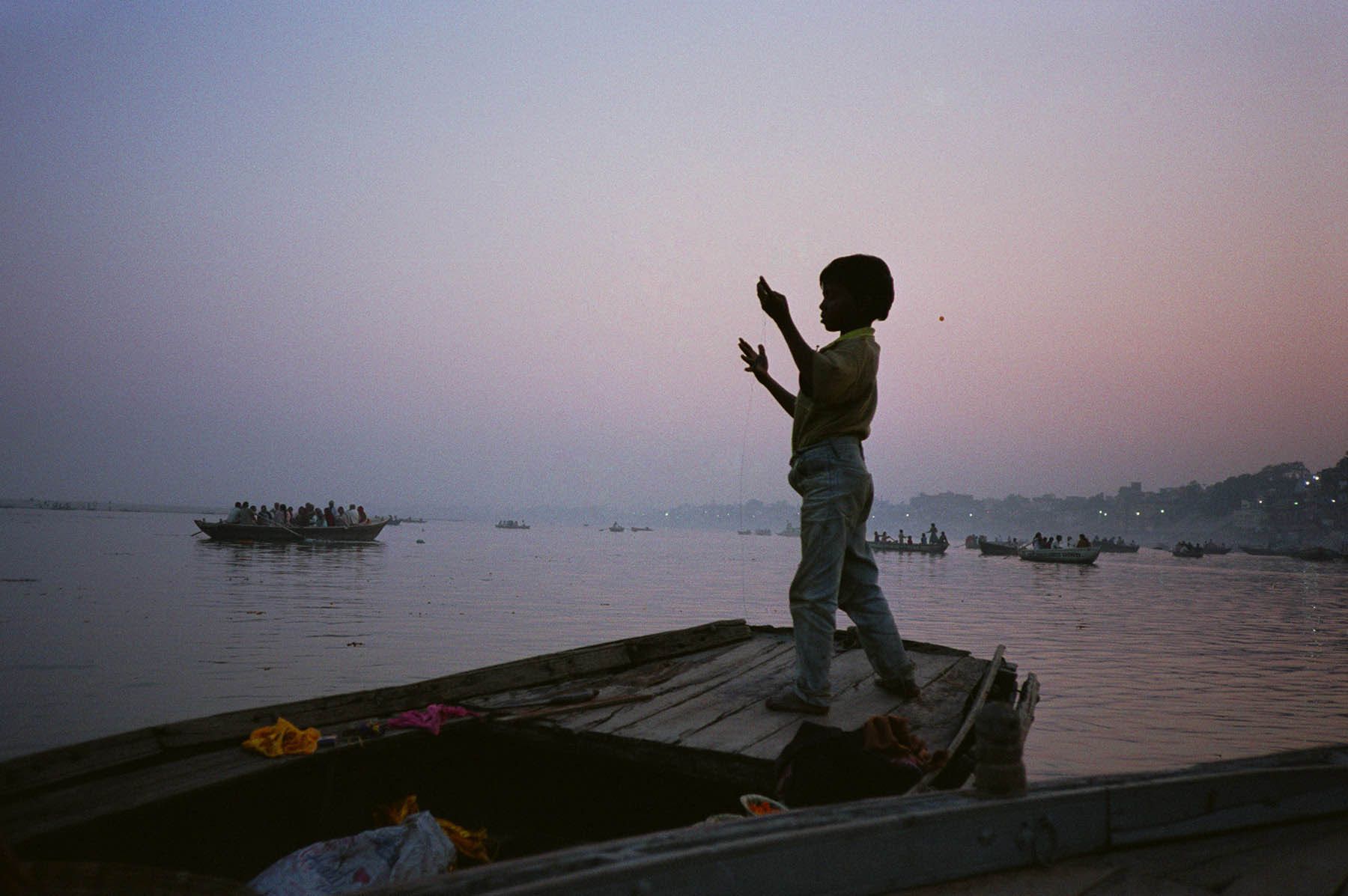 Boy fishing on the Ganges River, Varanasi, India