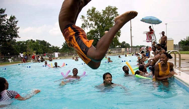 Trevon Powell, 12, takes a flying leap into the Cavalier Manor pool on it's opening day in Portsmouth, Va. The pool was going to be shut down for the summer until public outcry forced city officials to reverse the decision and open it. The pool was filled to maximum capacity on the opening day, as some swimmers were either turned away or waited at the gate for their chance to swim. 1Pool_photo_for_web