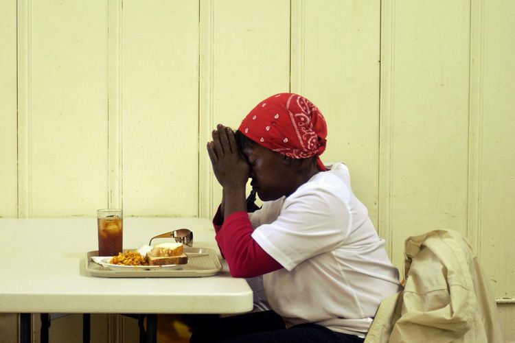 Marjorie Mackey prays before a meal at the Oasis Ministry soup kitchen in Portsmouth, Va. 1prayer