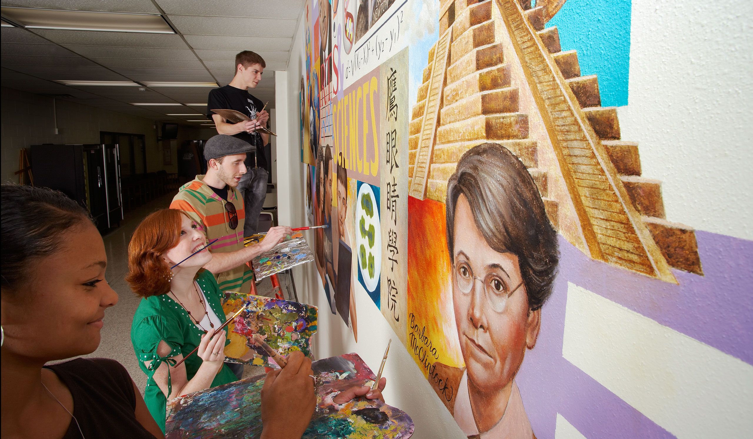 Art students painting mirror on hallway wall at Hawkeye Community College