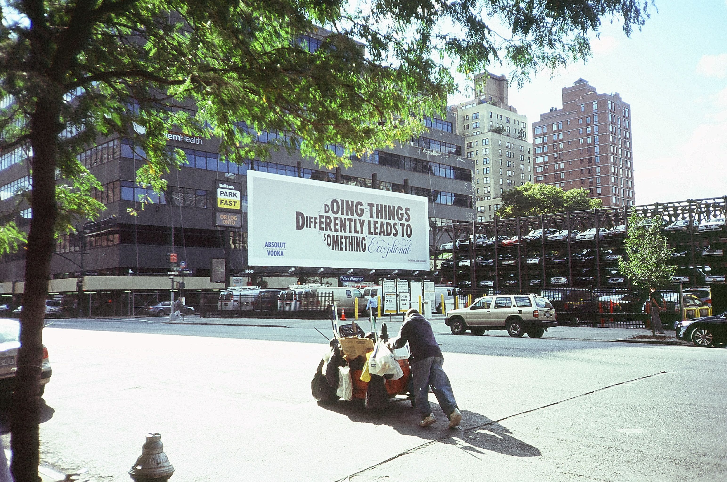 street person with extravagant billboard in the background Do it differently