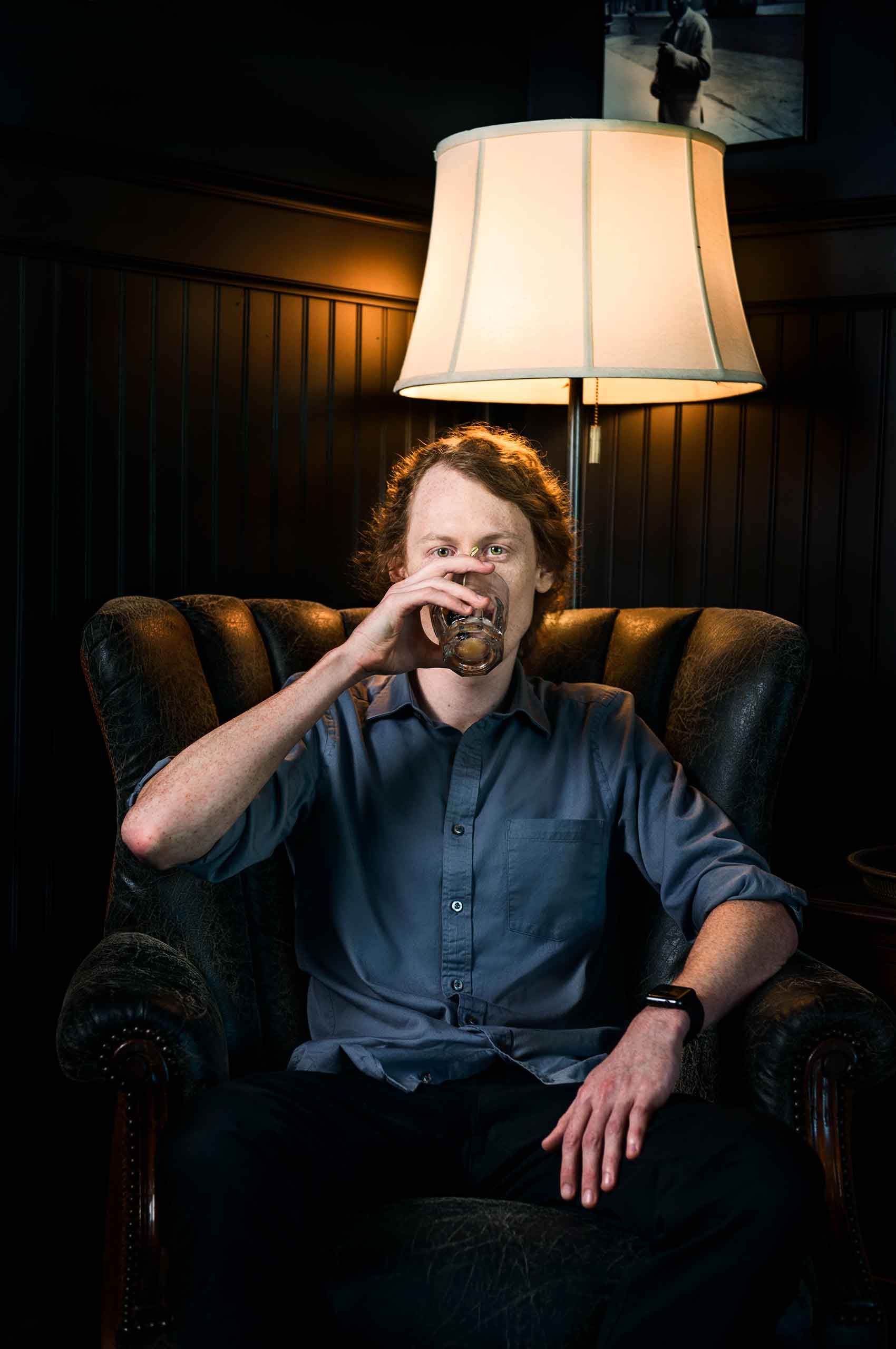Man-drinking-cocktail-in-clubchair-TimCaffin-by-HenrikOlundPhotography.jpg
