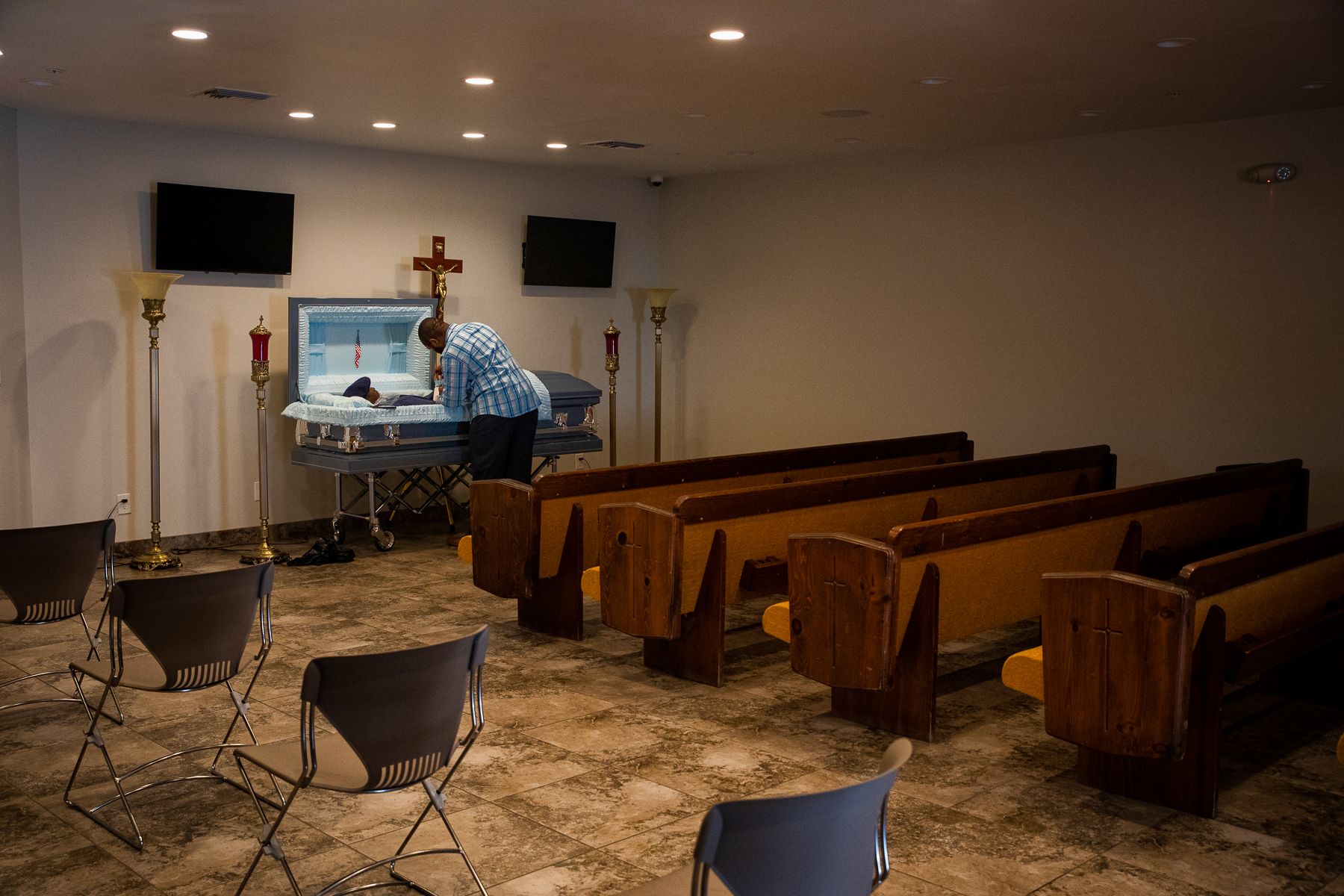 Reginald Burgan makes some final adjustments before a viewing at Peace Chapel Funeral Home in Phoenix on April 8, 2021. When COVID-19 restrictions were still in place, only a limited number of family members could enter the room at once. 2021_0423_FinalProject_Mariani-015.jpg