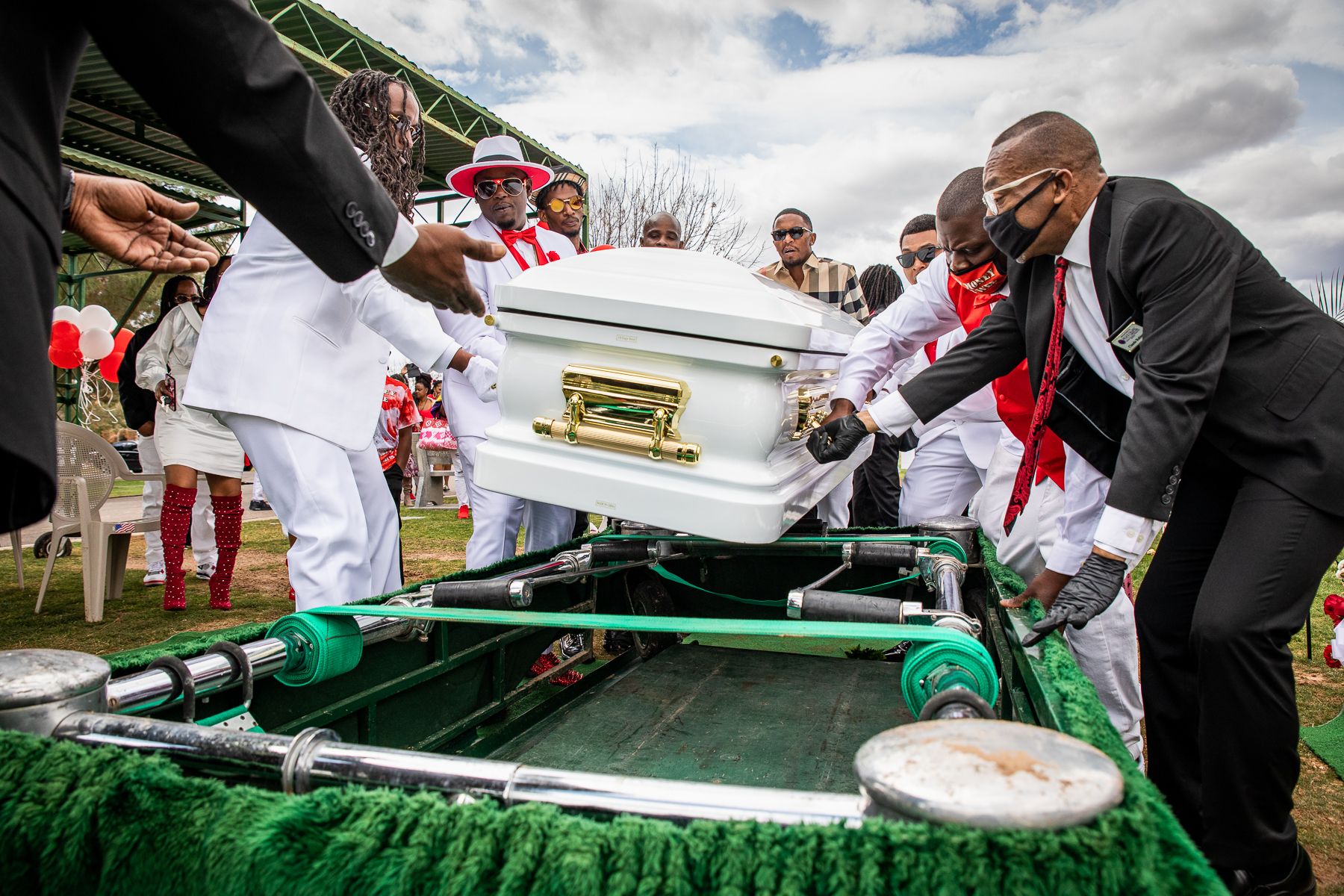 Peace Chapel funeral coordinator Claude Robinson and pallbearers lower the casket during a graveside ceremony at Resthaven/Carr-Tenney Mortuary & Memorial Gardens in Phoenix on March 13, 2021. Until recently, funeral services were limited to only a few people to prevent the spread of COVID-19 – bringing more despair on a day meant to help provide closure. 2021_0423_FinalProject_Mariani-021.jpg