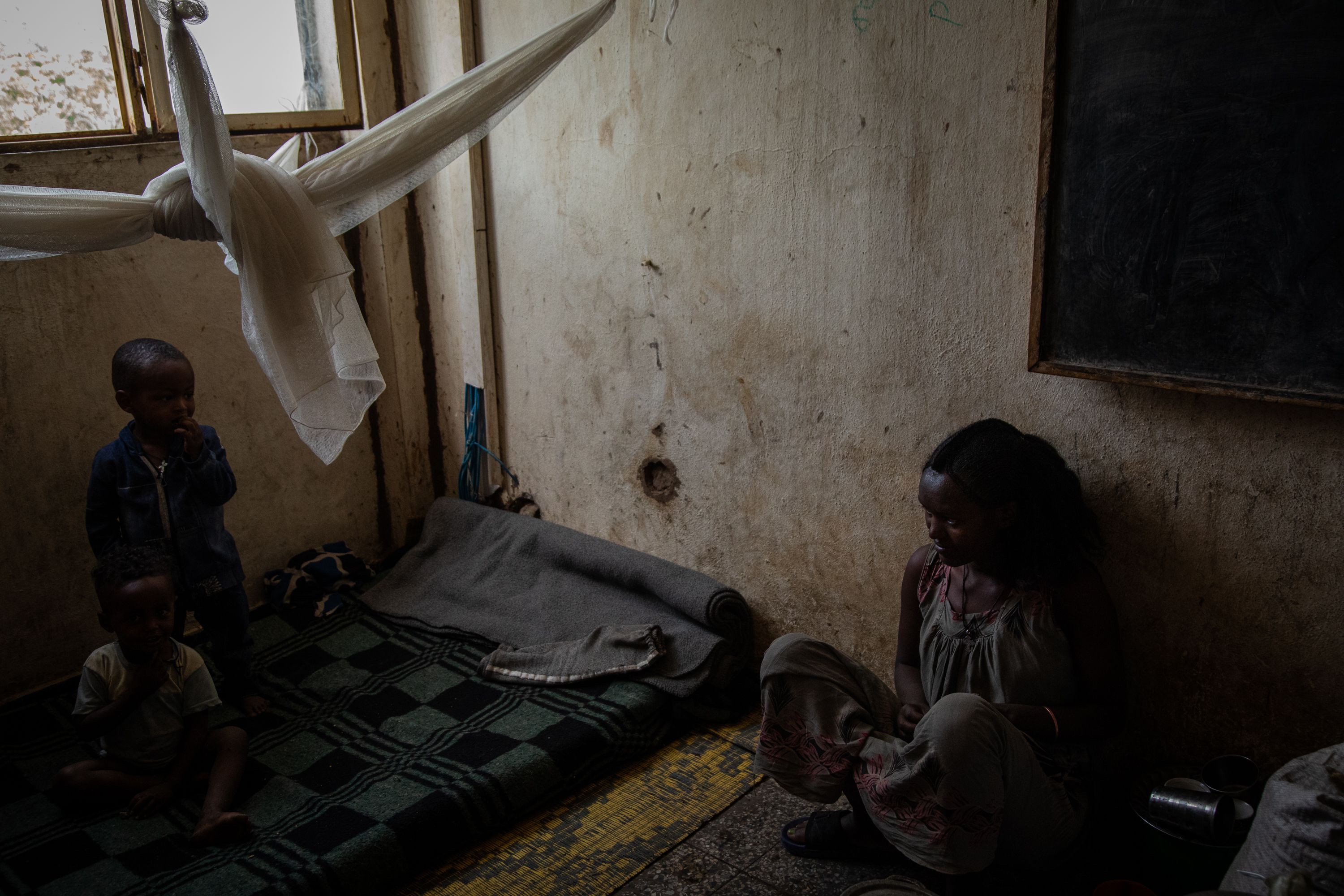 Lychee Fasehaye with her two children at a camp for internally displaced persons in Shire, Tigray, Ethiopia. Fasehaye and her two children have been living in the overcrowded camp for the past two years since they were forced to flee from violence in Western Tigray. Tigray'sPeacetimeCasualties_04002023-007.jpg