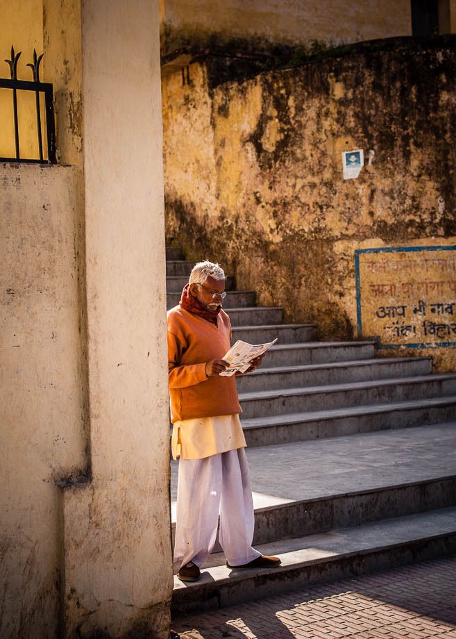 1man_reading_newspaper_in_sunlight_rishikesh_india