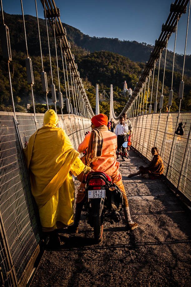 1men_in_orange_and_yellow_on_bridge_rishikesh_india