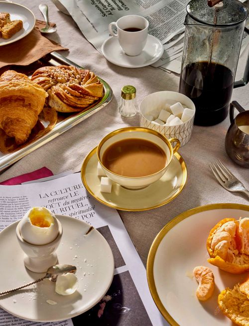 European breakfast with french press, baked goods fruit and eggs