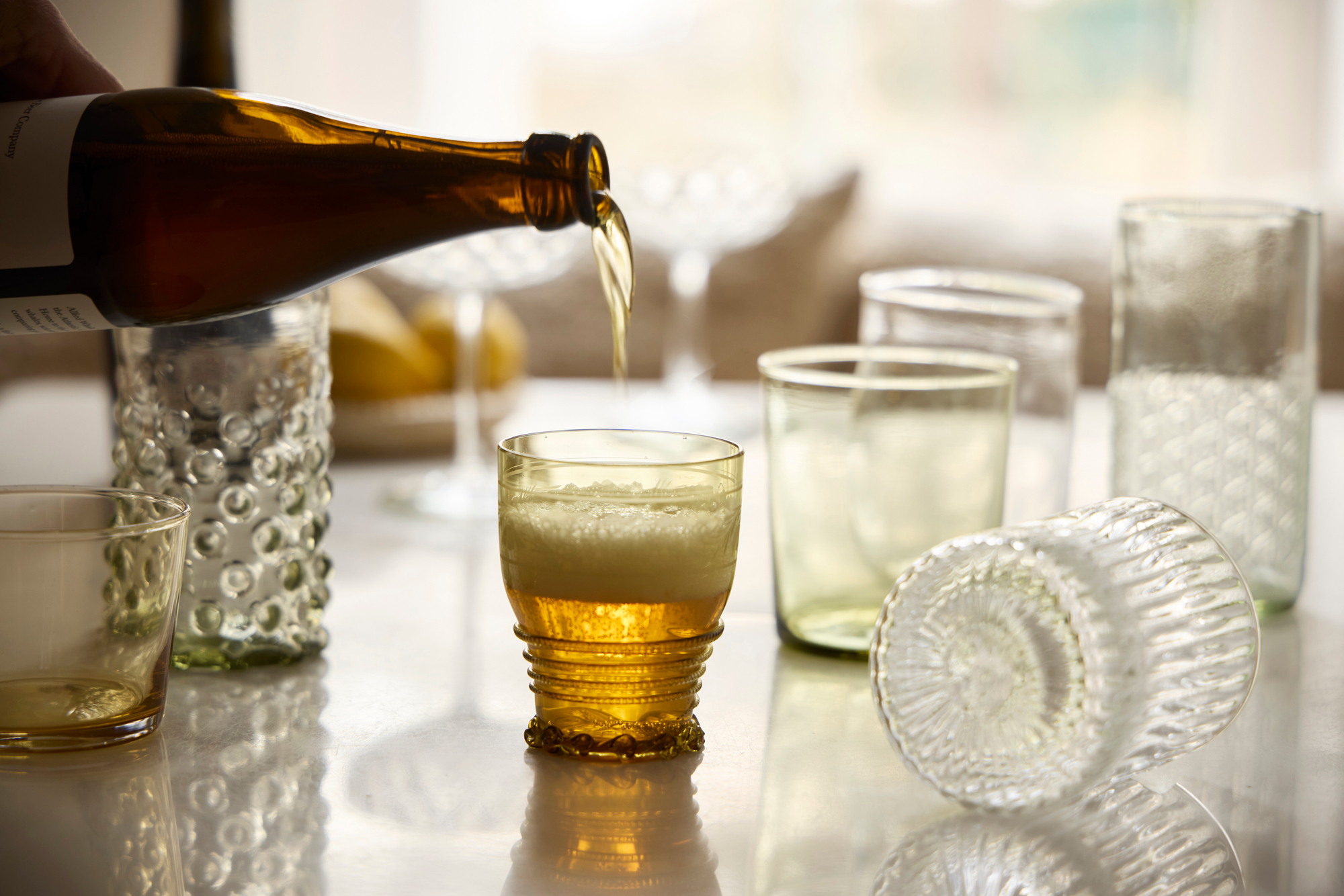 beer pours into glass by George Barberis Bottle Pours Into Clear & Golden Glasses