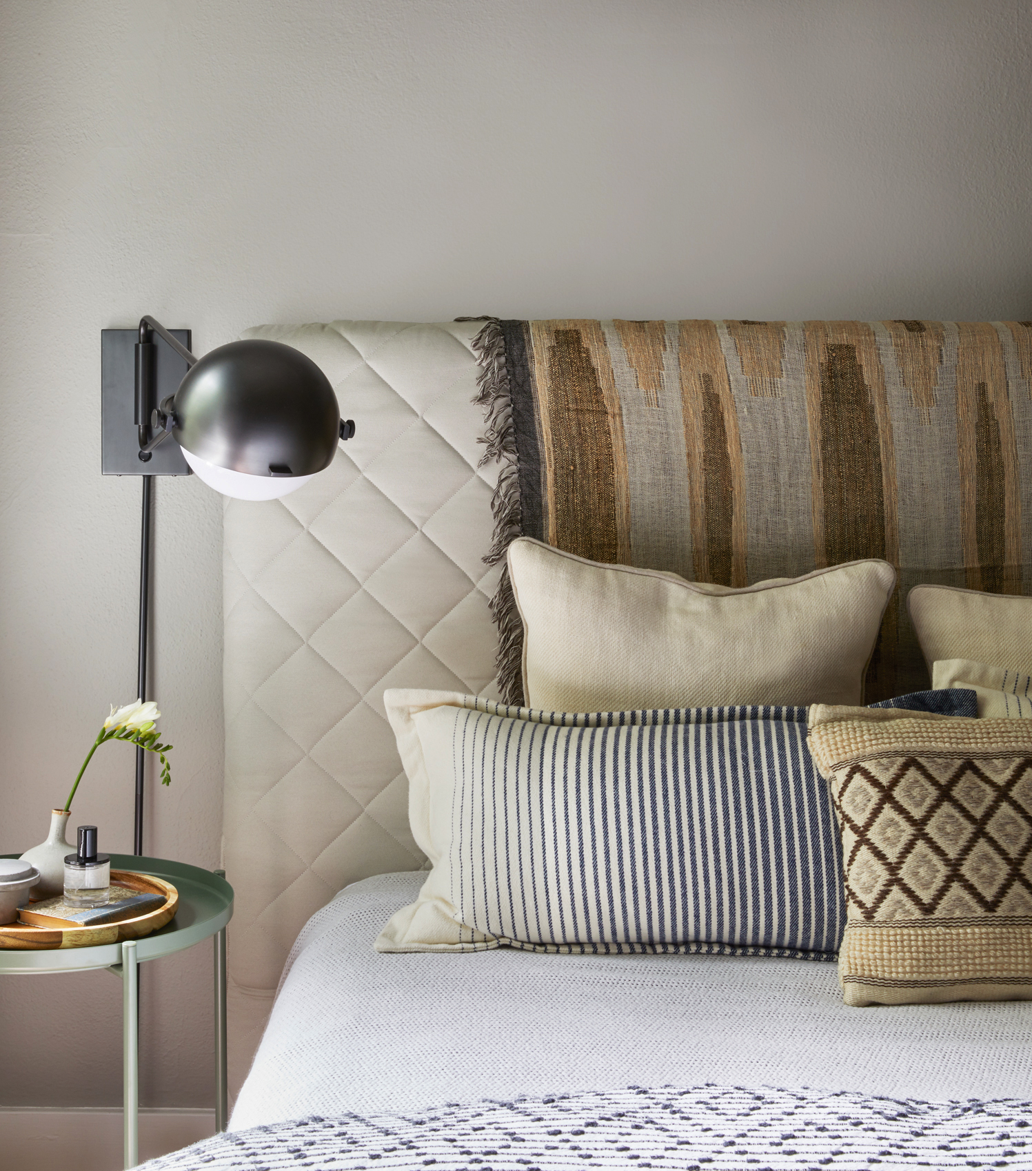 Close up of bed with modern reading lamp