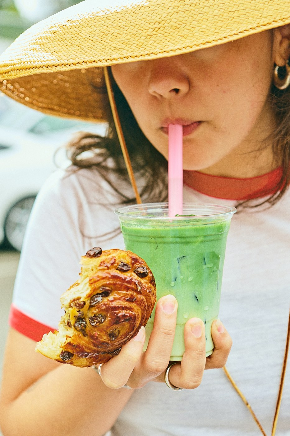 matcha with pink straw and raisin cinnamon roll 