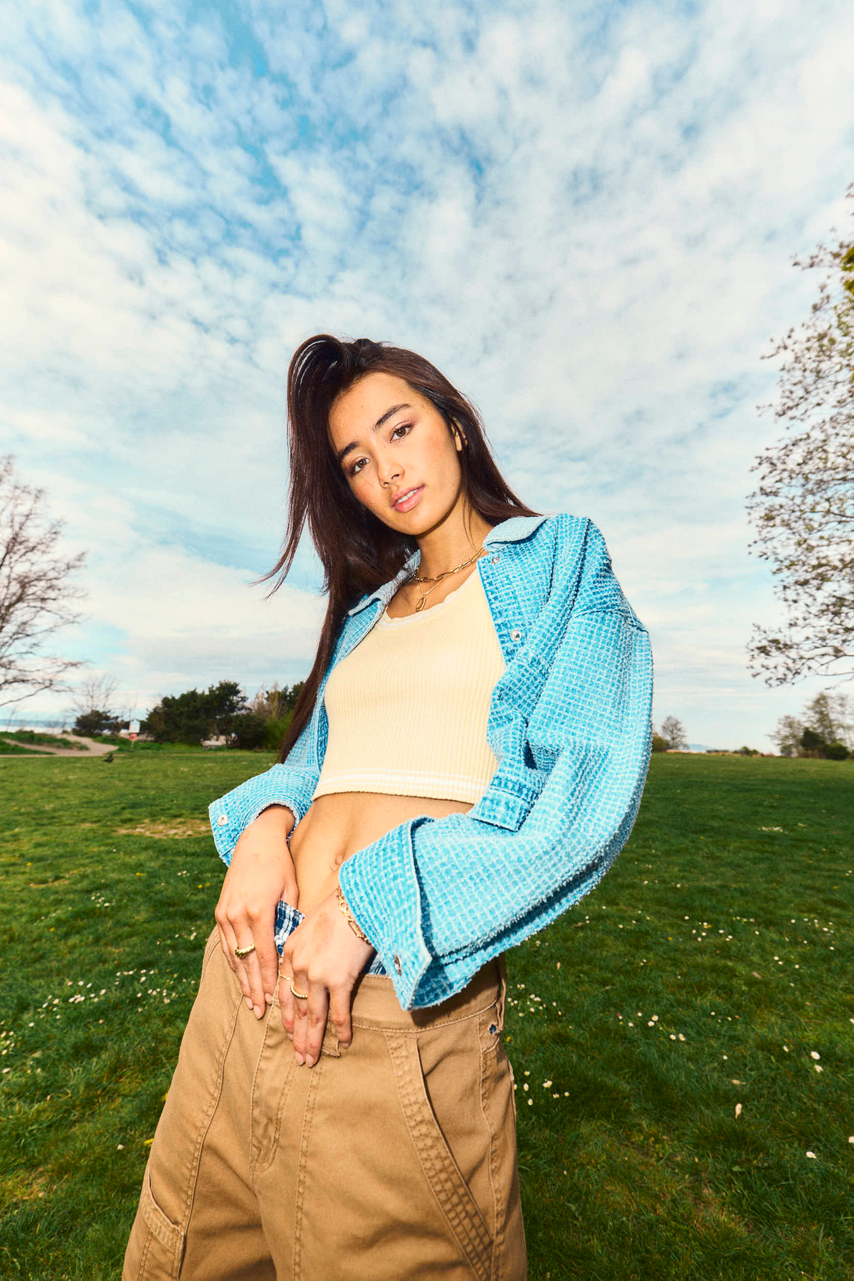 asian woman with dark hair and cool street style, blue button down crop top with tan cargo pants 