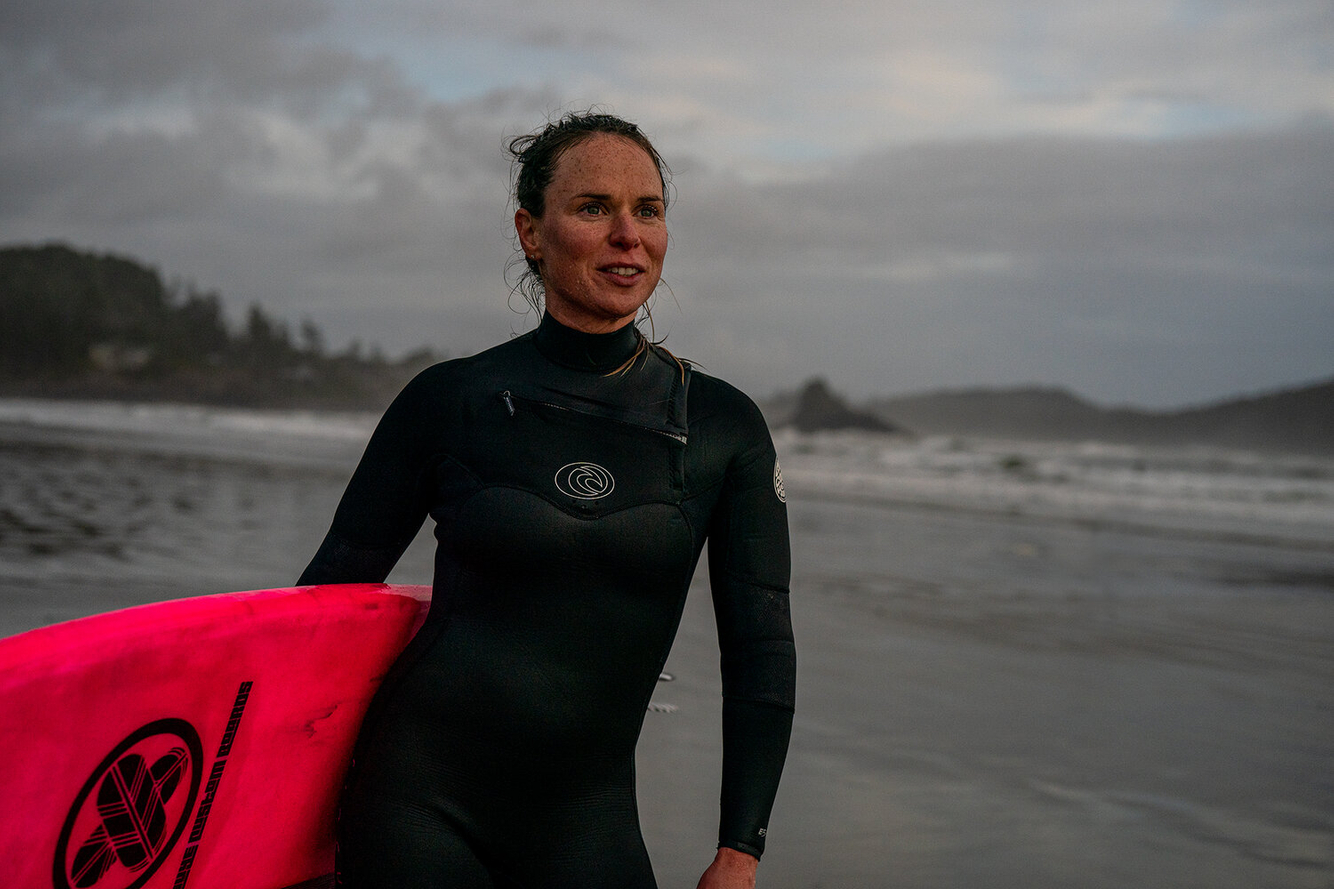 Aquatic sports photographer, beautiful portrait of a woman who surfs Grey sky sports