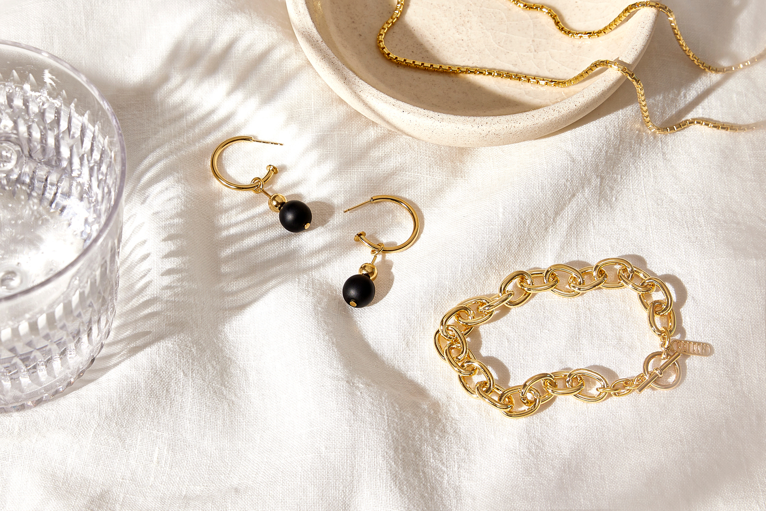 Gorgeous golden pieces and a pair of simple black pearl earrings Thick bracelet chain and thin necklace chain