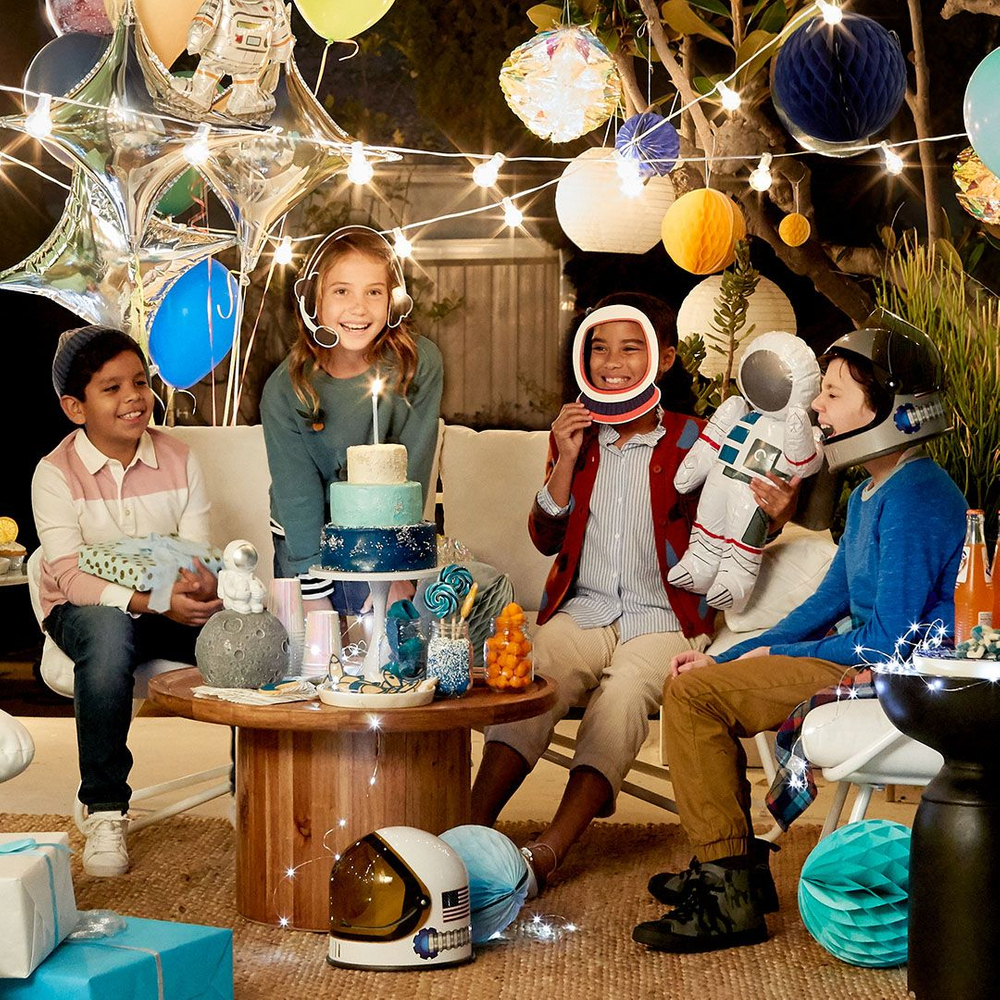 three kids sit on table outside at a space themed birthday party. photo retouching by jon birdseye 4 kids at a space themed party