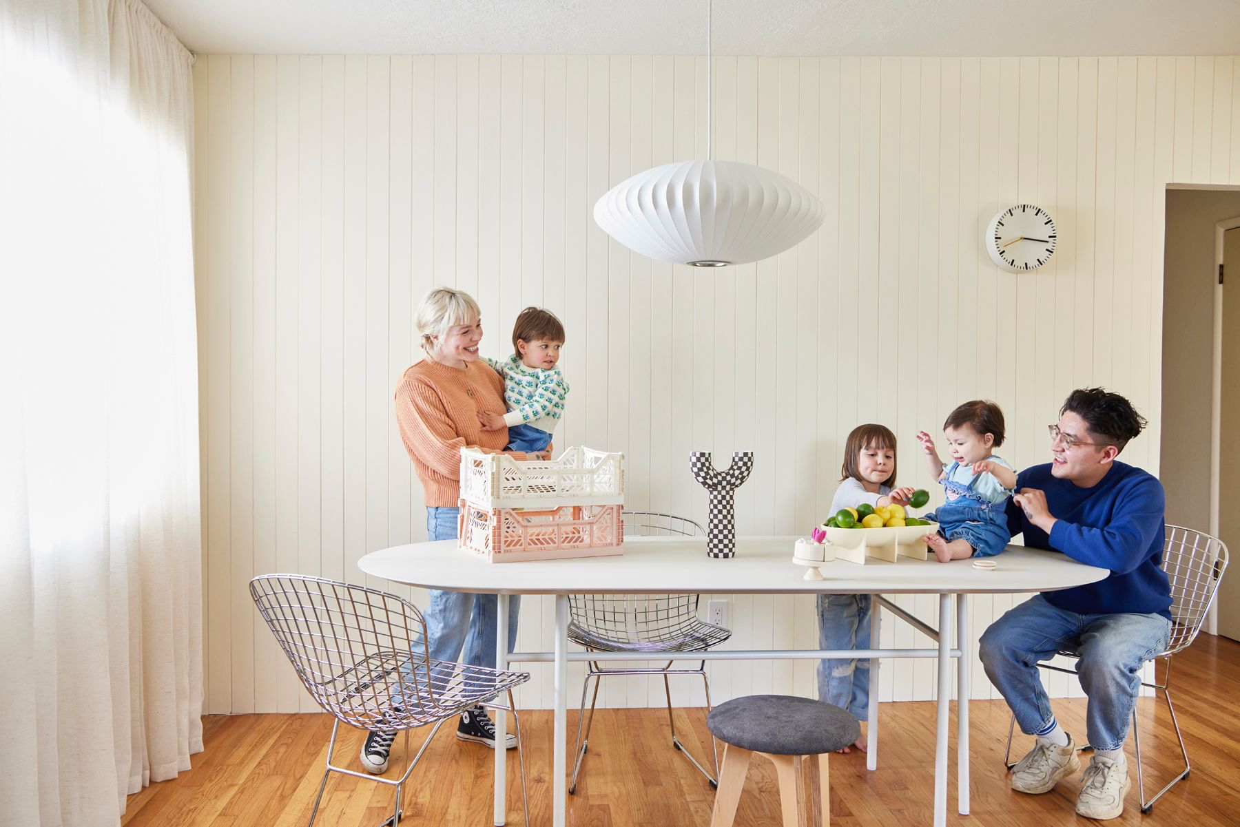 Mom and dad play with kids at their dining room table, photograph by George Barberis for Domino Family plays with baby at dining room table