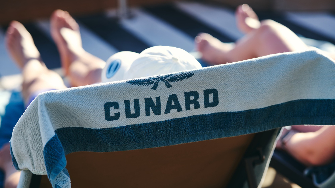 tourists enjoy a relaxing poolside day at cunard 