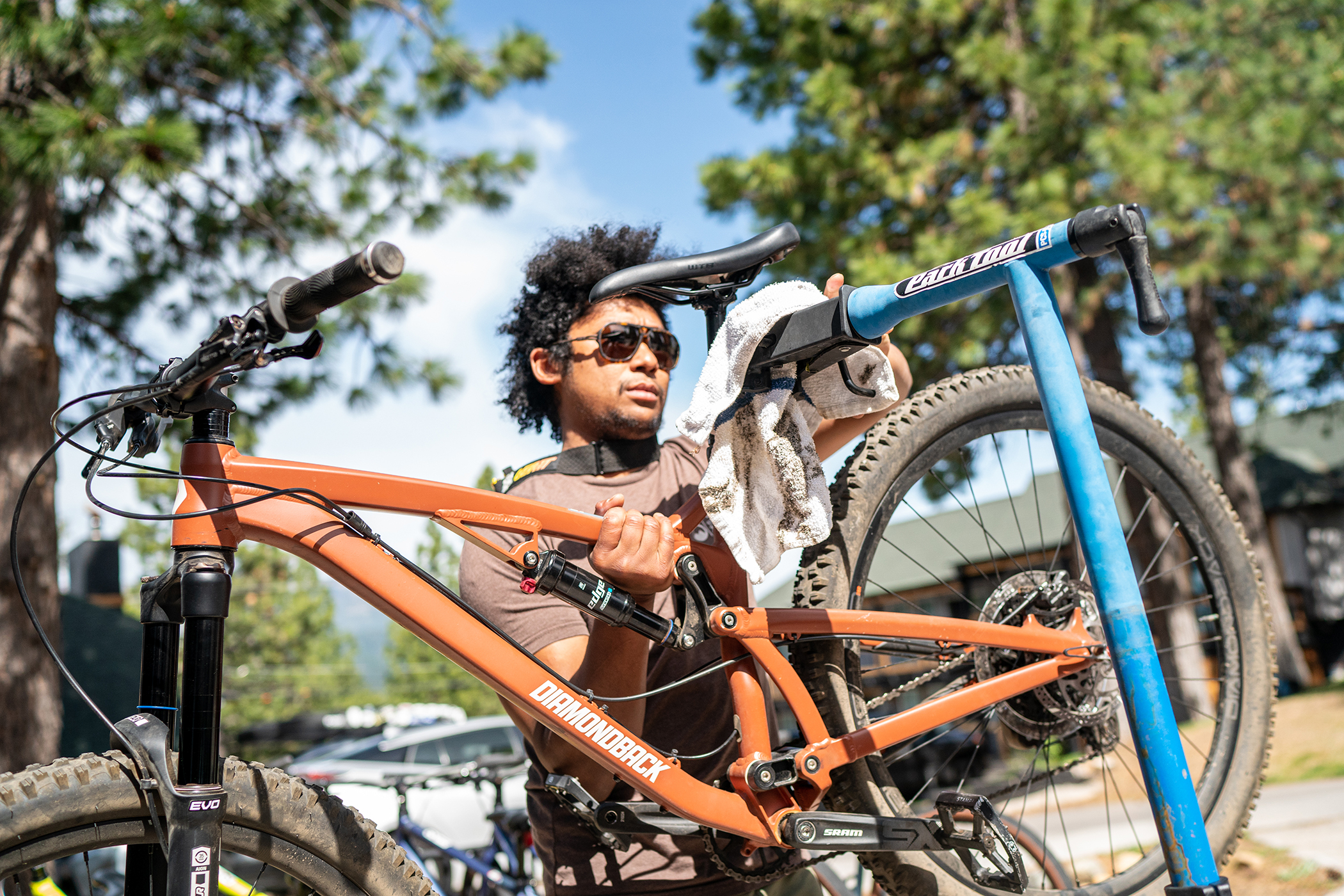 Cool bicycle mechanic, orange bike frame, outdoor cycling event Diamondback mountain bike