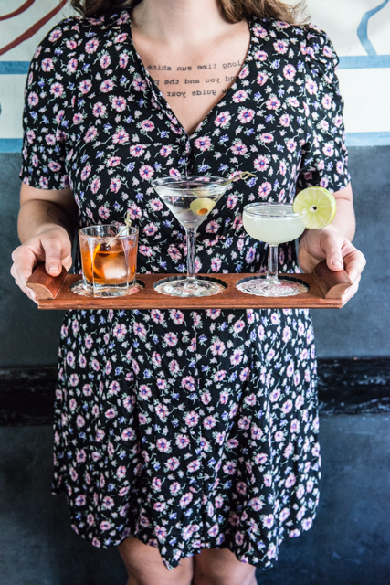 Beverages displayed on a tray by a fashionable restaurant worker/bartender Martini, margarita and an old fashioned