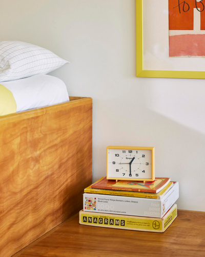 Stacked yellow books with clock on top 