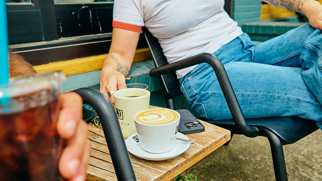 WOMAN DRINKING COFFEE OUTSIDE CUP OF JOE