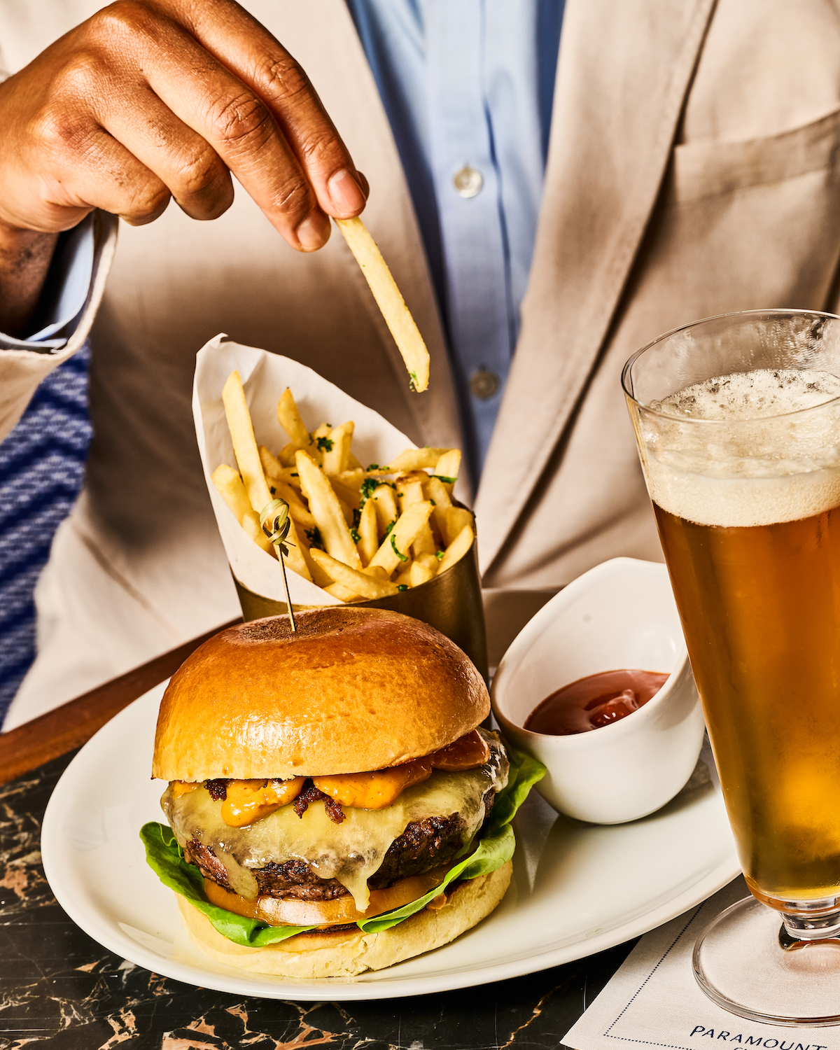juicy thick burger and. truffle fries with a beer paramount club lunch by Sarah Flotard