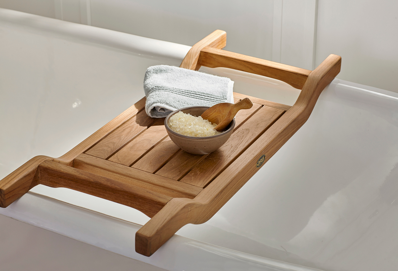 Bath tub tray sits over clean white tub with a towel and a bowl of Epsom salts 