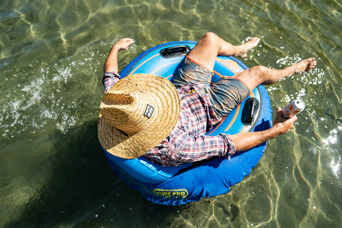 White man in flannel, grapefruit radler, river float  Summer relaxing
