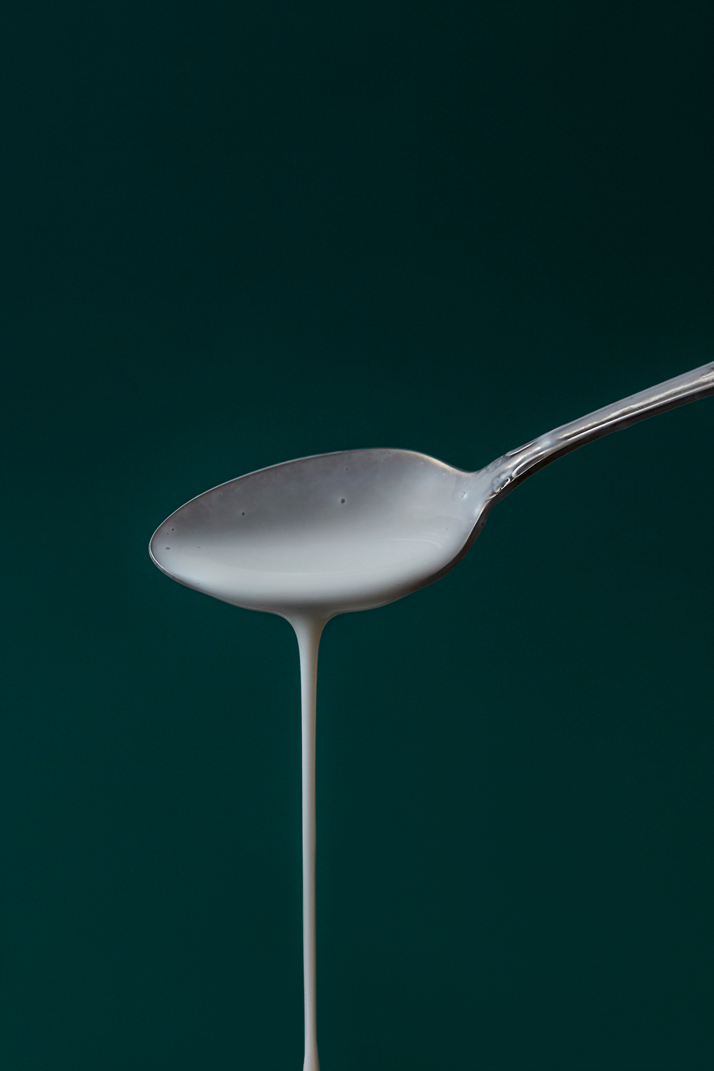 Food in motion, nutritious milk, use of contrast in advertising images, milk photography ad campaign, minimal and poignant spoonful of milk