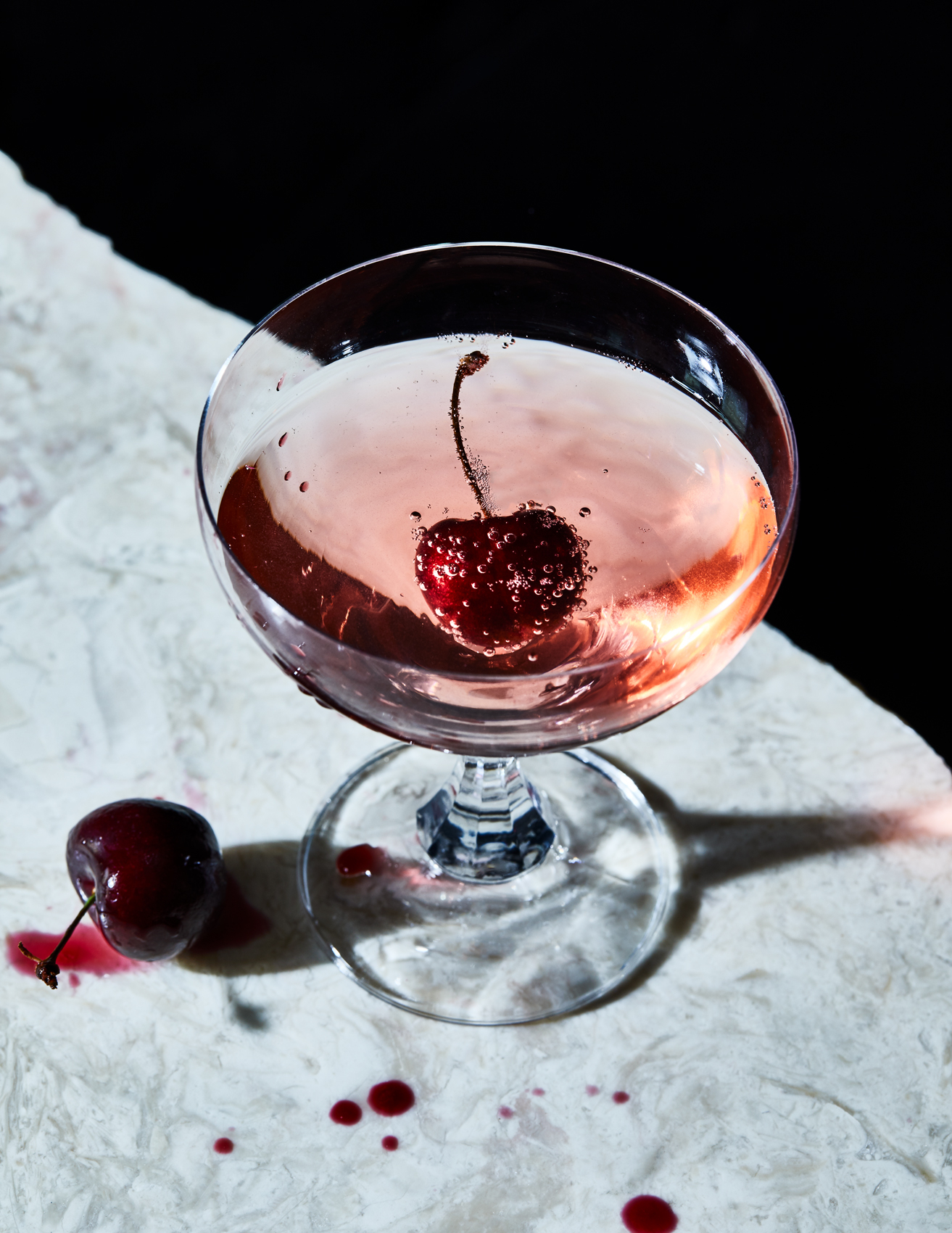 Burgundy cherry juice decorates marbled white surface